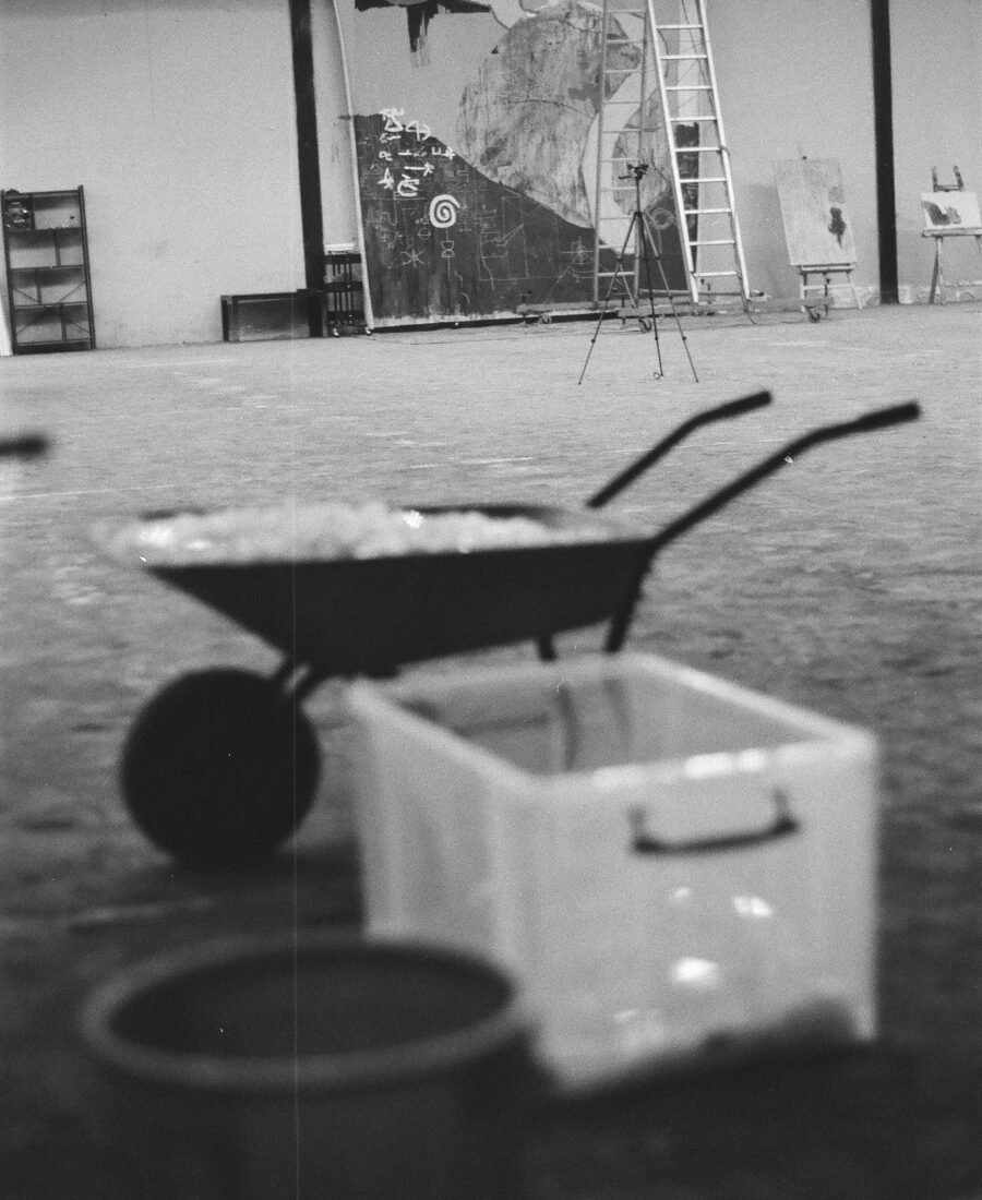 Analoge Schwarzweißfotografie von Marlon Nikolais Atelier mit Großformatarbeit, Leiter und Arbeitsmaterial.