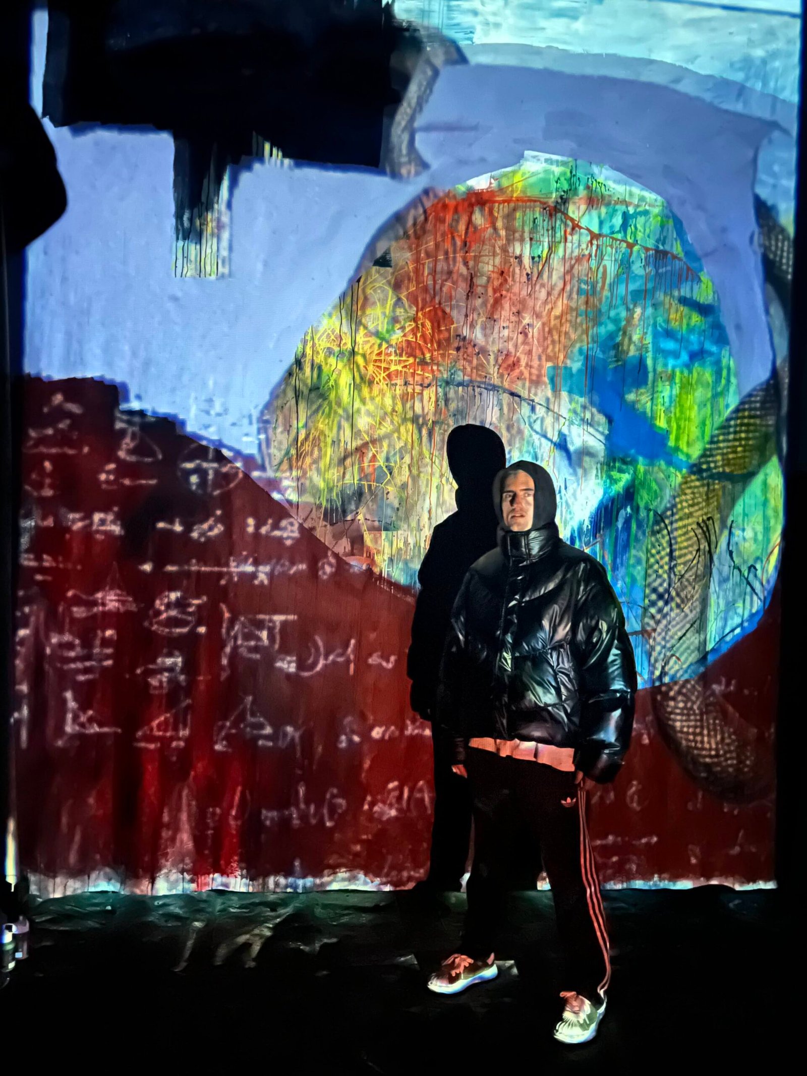 Marlon Nikolai innerhalb einer projizierten großformatigen Arbeit im Atelier.